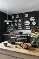 Modern country kitchen with display of white plates on black wall