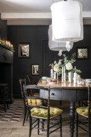 White flowers and lampshades in black painted dining room