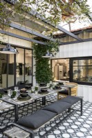Monochrome outdoor dining area with view to kitchen