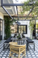 Brown wicker chair in otherwise monochrome outdoor dining area