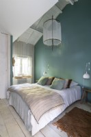 Teal painted feature wall in white country bedroom