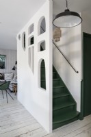 Green and white painted staircase with unusual cut out wall