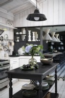 Black wooden island in country kitchen with view to dining room