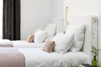 Pink and white bedding on twin beds