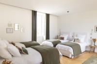 Green and white bedroom with four single beds 