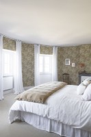 Circular bedroom with floral wallpapered walls
