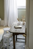 Rustic wooden table and white painted stools - furniture detail