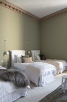 Three single beds in bedroom with green painted walls