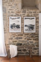 Framed paintings on exposed stone wall 