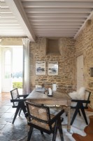 Wooden table in country living room with exposed stone walls