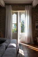 Long white drapes on French windows in country living room