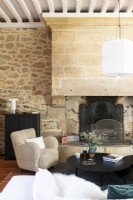 Large fireplace and exposed stone wall in country living room