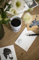 Detail of postcards and coffee on desk