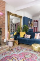 Large decorative guilt framed free standing mirror and blue sofa in a blue and pink living room