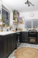 View into a monochrome kitchen with patterned floor tiles

