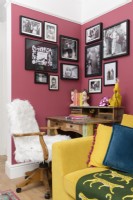Reclaimed wooden desk and fake fur covered office chair in the corner of a pink living room