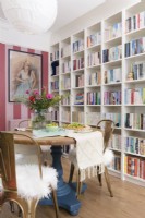 Pink striped wallpaper and bookshelves in a dining area 
