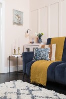Dark blue sofa in a pale pink living room with feature panelling