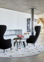 Black armchairs and circular rug in contemporary living room