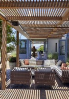 Outdoor living area under pergola on terrace of country house