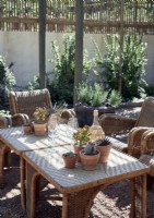 Glassware and potted cacti on wicker table in outdoor seating area