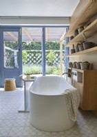 Modern country bathroom with view to courtyard garden