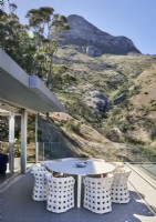 White table and chairs on terrace with views of mountains