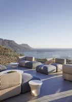 Sofas armchairs and footstools on large terrace with sea views