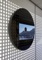 Detail of circular mirror with reflection showing outdoor living space