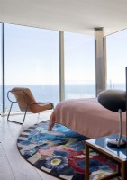 Vibrant circular rug in contemporary bedroom with sea views 