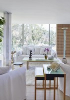 White contemporary living room with glazed walls and garden views