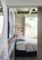 Country bedroom with exposed stone wall and patio doors