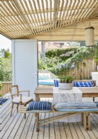 Blue and white cushions on seats around outdoor dining table