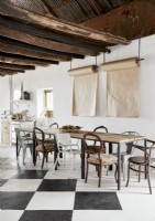 Modern rustic dining room with mismatched chairs and exposed beams