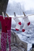 Detail of socks and stockings hangin on rope outside after Christmas skating party