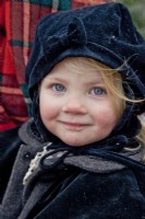 Little girl dressed with winter hat and coat for a sleigh ride at Christmas