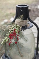 Outdoor lantern decorated for Christmas with greenery and berries