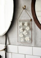 Detail of framed dried flowers on bathroom wall