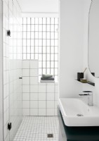 White tiled bathroom with green and white sink