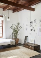 Display of pencil drawings on wall of simple country bedroom