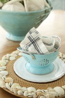 Whether on their own or on place  mats, shells and varied shades of blue and aqua are reoccurring motifs in the waterside cottage.
