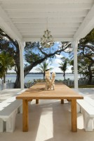 The loggia was built to host easy get-togethers with family, friends and neighbors. A large teak table and custom benches provide ample space to fit more guests around the table casually and comfortably. 