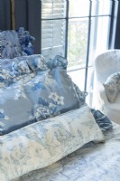 Renee keeps the bedroom French blue and white theme fluid with pillows sporting variations on the hues and floral and pastoral patterns.