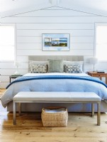 The modern upholstered bed in a neutral color answers Lindaâ€™s preference for a clean and contemporary direction. The cool blue and white bedding contributes to the serene space sense of calm and elegance.