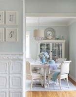 In the dining room, coats of white paint unify secondhand finds into and elegant design set.For something different from traditional wainscoting, Rachel used tin ceiling tiles below the chair rail in the hallway.