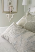 Monochromatic bedding gets a boost with texture and patterns and bring interest and comfort to the small bedroom.