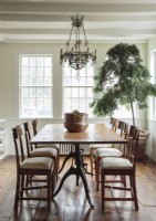 Natural light bathes the countryside dining room, which is simply but elegantly furnished with favorite vintage chairs and an ample antique table. 
