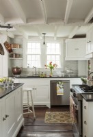 Old copper cooking pots and pans warm modern stainless appliances, while adding country charm to the updated kitchen. 