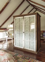 The wardrobe was constructed with locally sourced barn boards and Victorian pantry windows lined with inexpensive cotton lace. 