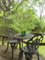 The couple furnished the place with rustic and secondhand finds from local stores, including this tiny bistro set that is just the right size for the narrow deck.
